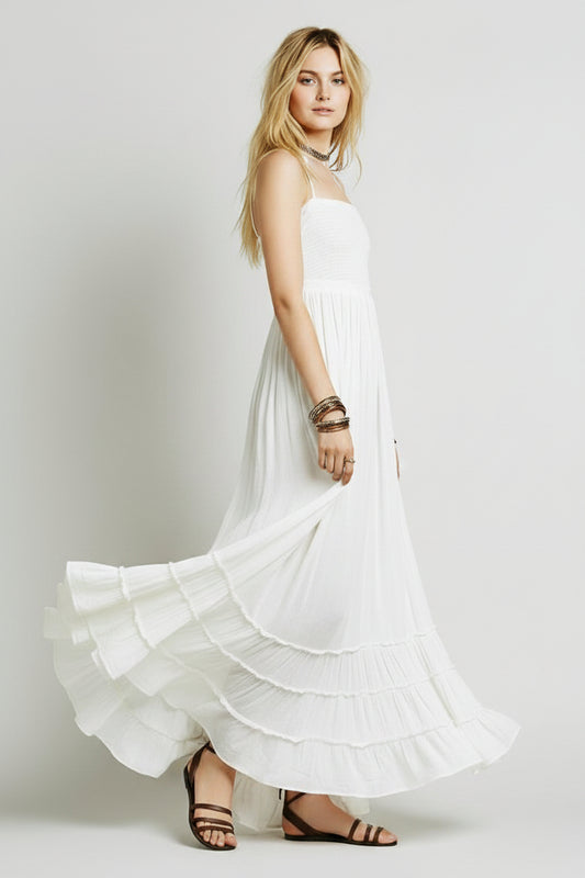 A woman wearing a beige, backless, bandage wrap chest, boho beach dress with spaghetti straps and ruffled hem.
