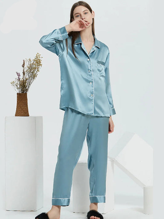 A woman wearing a blue 100% silk pyjama set with a turn-down collar and ankle-length pants.