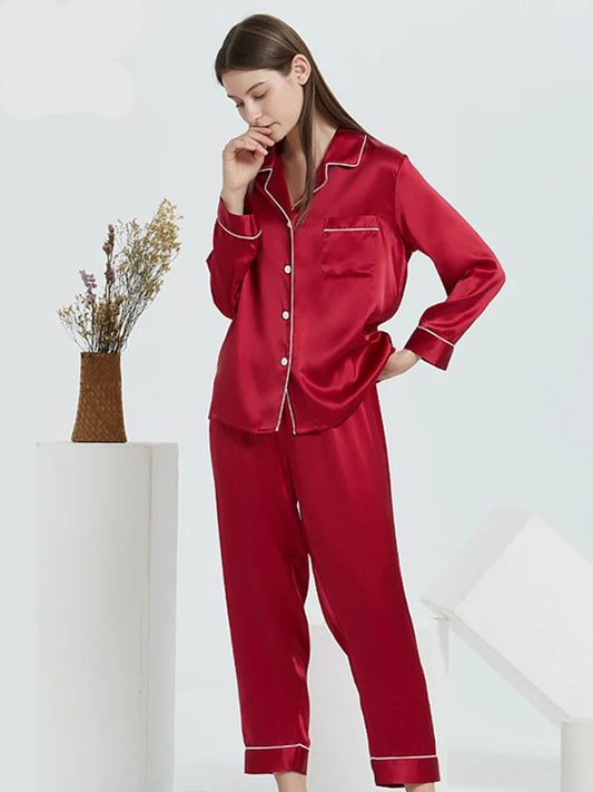 A woman wearing a red 100% silk pyjama set with a turn-down collar and ankle-length pants.