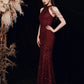 A woman models a floor-length, sleeveless burgundy sequined gown with cutout shoulder details against a dark backdrop with dried floral decor on the left.